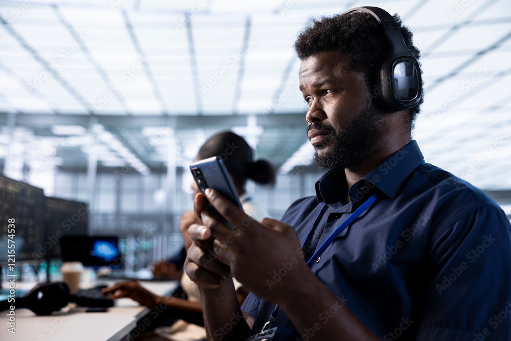 Poster man in data center listening music and texting friends on smartphone while using diagnostic tools to