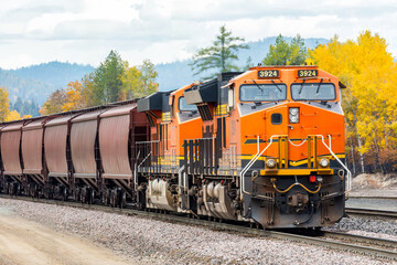a freight train traveling on a beautiful day in autumn near Whitefish, Montana