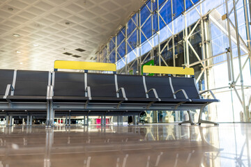Naklejka premium A bright and modern airport terminal that features sleek seating arrangements and expansive large windows, showcasing the vibrant and lively atmosphere that accompanies the experience of travel