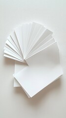 A fan of blank white paper sheets arranged creatively on a textured background.