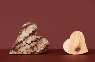 Herzen aus Holz mit Rinde und ohne Rinde vor einem roten Hintergrund