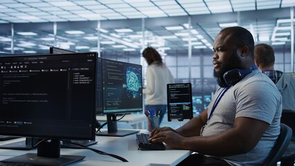 Engineer working in high tech establishment providing computing resources for different workloads. African american man tasked with monitoring data center supercomputers, camera B
