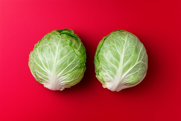 Fototapeta premium Two Green Cabbages on Red Background