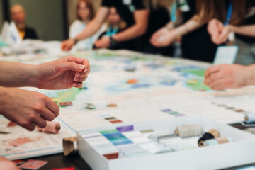 Obraz premium Process of playing tabletop board game on the table, fun with friends and family in room indoors, board game party concept, company group of students adults play board games, roll the dice on game map