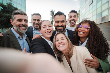 Selfie. Diverse group of business professionals smiling and looking at the camera during an outdoor meeting, showcasing teamwork. Successful businesspeople looking at camera together at the downtown