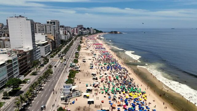 Aerial View of Leme Beach and Coastal Skyline in Rio de Janeiro, Brazil, with Colorful Umbrellas, Crowds, and Ocean Waves