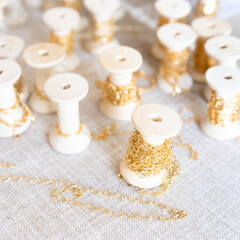 Jewelry chains on wooden spools, gold