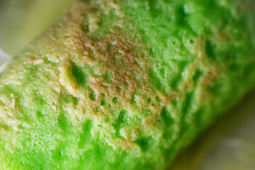 Coconut grated Pandan crepe know as Kuih Dadar. It is combination of sweet filling made from grated coconut and gula Melaka, wrapped in delicate, soft green crepes