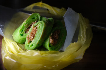 Coconut grated Pandan crepe know as Kuih Dadar. It is combination of sweet filling made from grated...