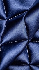 Naklejka premium Prom night style fashion concept. A close-up of a textured, navy blue fabric featuring a quilted pattern, showcasing a smooth, shiny surface with highlighted stitching.
