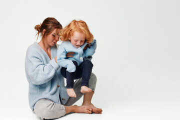 Bonding moment woman and little girl sitting together on the floor embracing in a warm and loving gesture