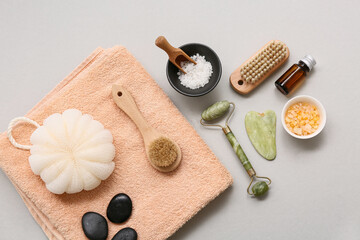 Composition with bath supplies, guasha, sea salt, facial massage tool  and spa stones on white background