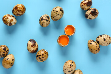 Composition with raw quail eggs on blue background