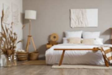 Stylish interior of bedroom with picture on wall, blurred view