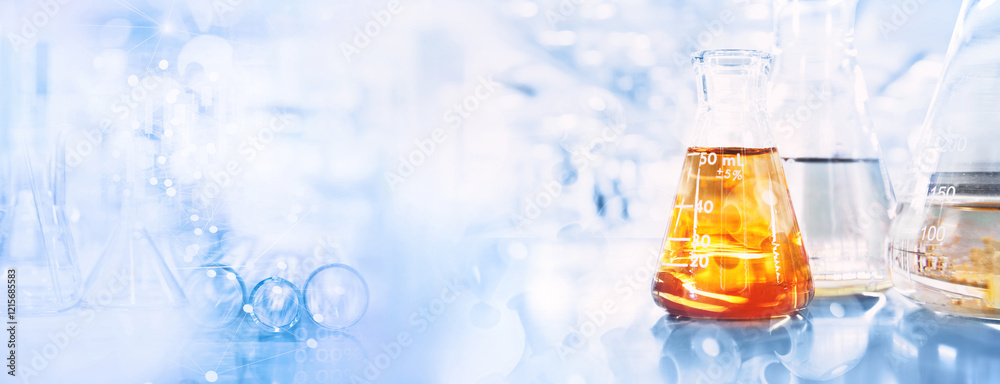 Wall mural orange solution in flask and test tube in science research lab with blue banner background