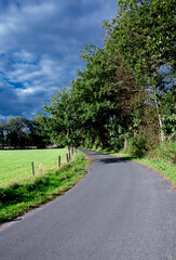 A road in the countryside with some clouds in the background