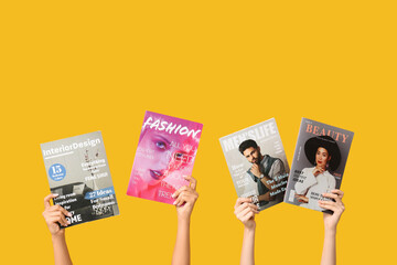 Female hands with different magazines on yellow background