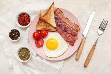 Plate with fried egg, bacon, toasts, tomatoes and spices in bowls on white grunge background. Top view