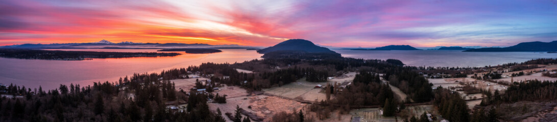 Panoramic aerial view of the south end of Lummi Island, Washington, during a glorious sunrise. Dramatic clouds and a frosty landscape make for a unique view of this rural area in the Pacific Northwest