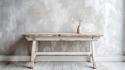 Obraz premium Aged White Wooden Table with Minimalist Vase on Textured Gray Wall in Contemporary Studio Setting with Light Hardwood Floor