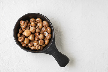 Frying pan with roasted mushrooms on white background
