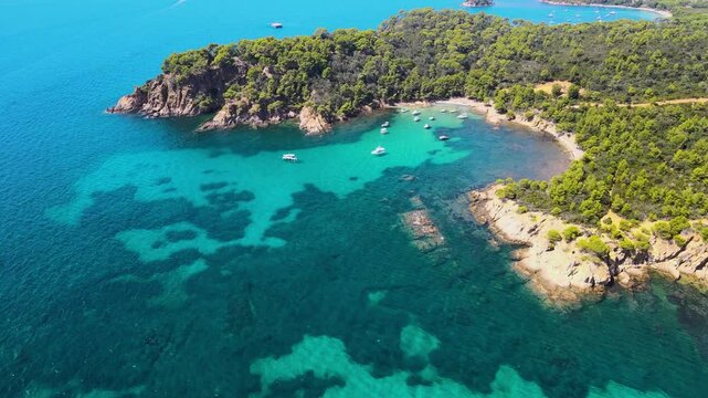 Aerial view of &Icirc;les d'Hy&egrave;res - France, Porquerolles Island. Luxury yachts, spectacular landscape with small water bays. Turquoises water colour. Famous travel destination. Drone forward.