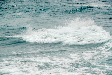 A beach with dark blue waves and a white foamy summer background