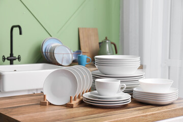 Clean white dishes on wooden table in kitchen