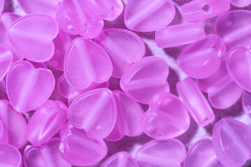 Fototapeta premium Pink heart-shaped beads as background, closeup