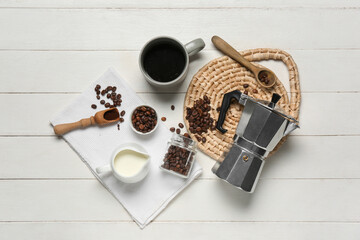 Geyser coffee maker with cup, jug of milk and beans on white wooden background