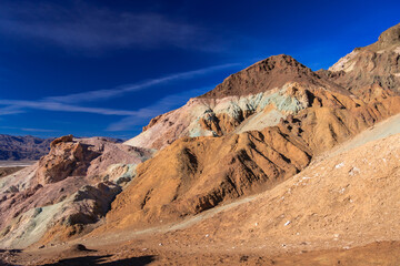 A mountain range with a blue sky in the background