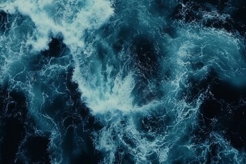 Aerial view of dark blue ocean waves with white foam.