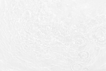 White water with ripples on the surface. Defocus blurred transparent white colored clear calm water surface texture with splashes and bubbles. Water waves with shining pattern texture background.
