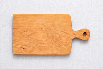 Handmade cherry wood chopping board. wooden cutting board. Empty cherry wood chopping board on sackcloth tabletop.