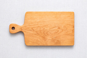 Handmade cherry wood chopping board. wooden cutting board. Empty cherry wood chopping board on sackcloth tabletop.