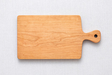 Handmade cherry wood chopping board. wooden cutting board. Empty cherry wood chopping board on sackcloth tabletop.
