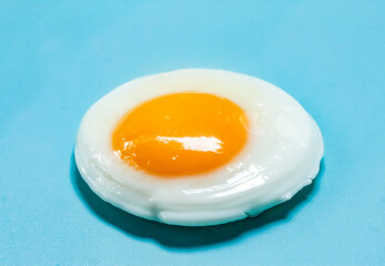 a fried egg isolated on a blue background