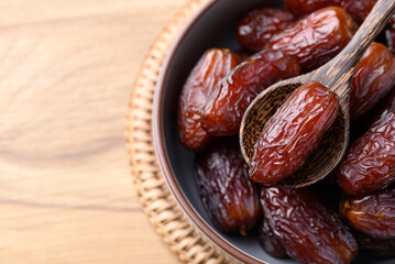 Date palm fruit (MedJool) in bowl with spoon, Top view