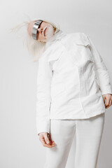Futuristic fashion model in white outfit with silver visor on minimalistic background, showcasing...