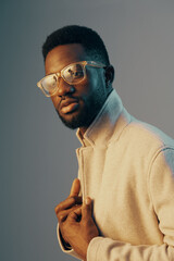 Stylish young man in glasses wearing a light coat, showcasing confidence against a gradient background with soft lighting, perfect for fashion and lifestyle concepts
