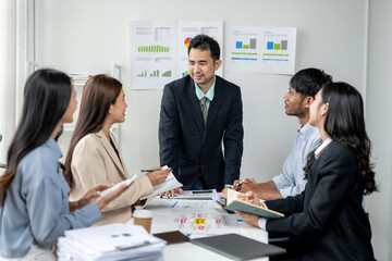 A group of people are sitting around a table with a man in the middle