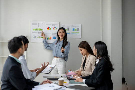 A woman is giving a presentation to a group of people in a conference room - Powered by Adobe