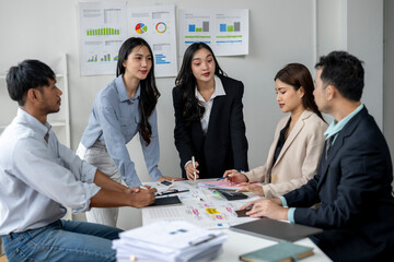 A group of people are sitting around a table with papers and a calculator