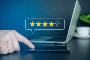 close up Man tabel leptop hand using smartphone with popup five star icon for feedback review satisfaction service, Customer service experience and business satisfaction survey.