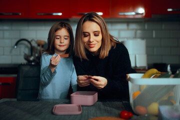 Mother and Daughter Enjoying Chocolate from a Casserole. Permissive mom is letting her kid have dessert before lunch time
