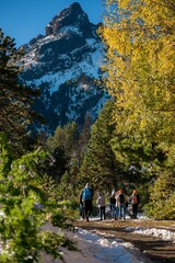 Hikers on a scenic trail with a mountain backdrop.