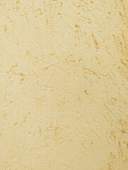 Cream yellow rough scratched cement or concrete wall texture or background with uneven and irregular grooves and reliefs. Mediterranean rustic architectural outdoor style.