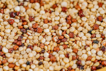 Mixed red, white and black quinoa as an abstract background texture. Close-up of mixed quinoa grains, showcasing white, red, and black seeds, perfect for health, nutrition, and food-related concepts.