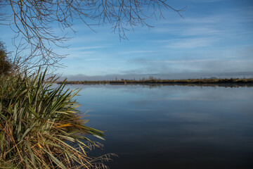 The river Taieri at sunrise where it becomes an estuary and the Historic Henley suspension bridge over the river Taieri at Otokai in the early morning