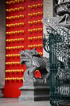 The red gate of Xingtian Temple stands as a striking symbol, adorned with glowing doornails and flanked by powerful stone lions and intricately carved dragon pillars, exuding cultural richness.